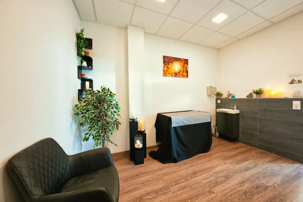 Abschiedsraum in Korb mit Sessel, brennenden Kerzen und dem abgedeckten Tisch