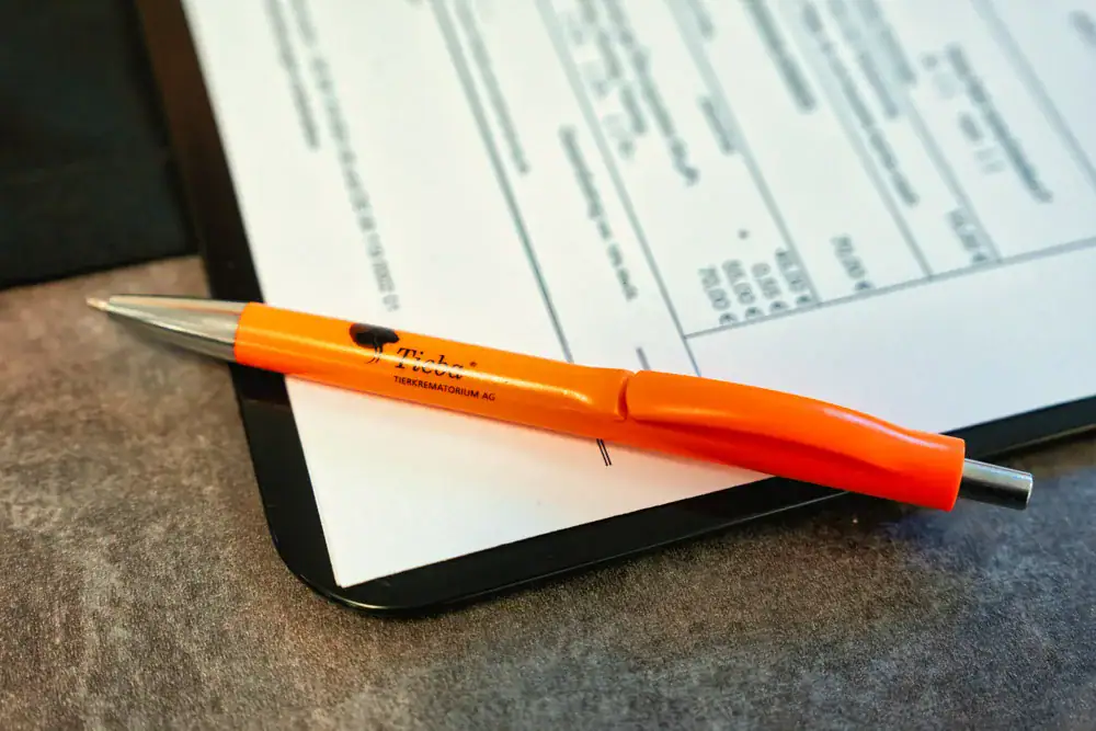 Auftragsformular von Tieba mit orangefarbenem Stift auf dem Beratungstisch